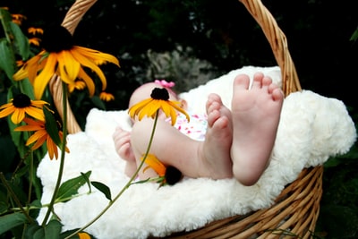 Baby lying on a brown wicker basket
